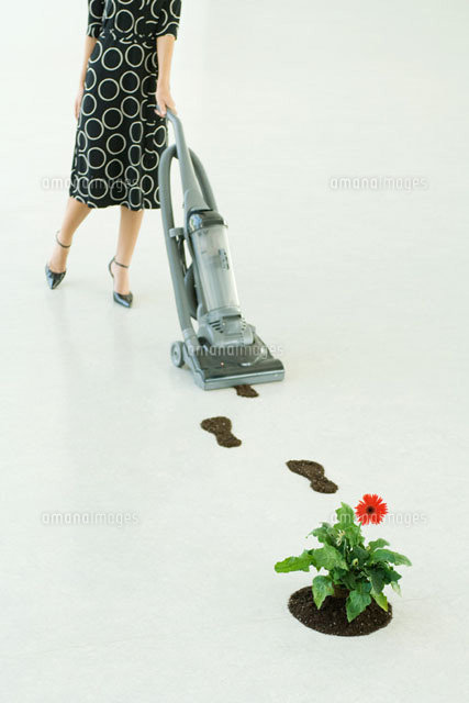 Woman vacuuming up footprints of soil
(c)Milena Boniek/Photo Alto