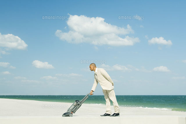 Man using vacuum cleaner on beach
(c)Milena Boniek/Photo Alto