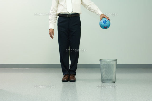 Businessman holding globe over trash can
(c)Milena Boniek/Photo Alto