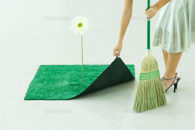 Woman sweeping under artificial turf rug
(c)Milena Boniek/Photo Alto