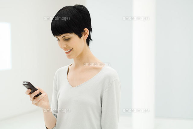 Woman looking down at cell phone
(c)Eric Audras/Photo Alto