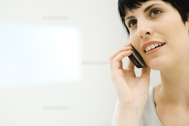 Woman using cell phone, smiling
(c)Eric Audras/Photo Alto