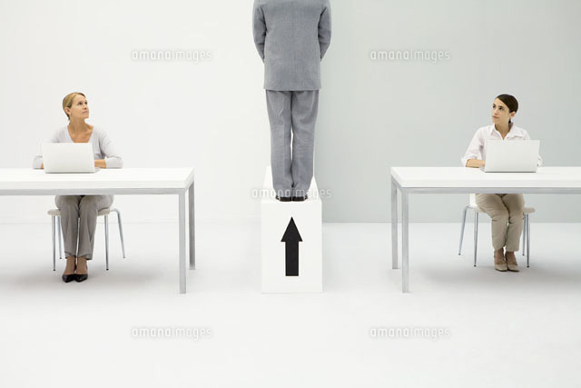 Two women sitting at desks, both looking at man standing
(c)Ale Ventura/PhotoAlto
