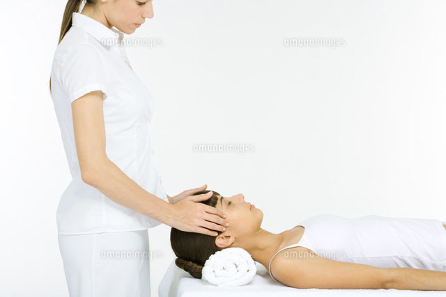 Woman lying on her back receiving head massage, eyes closed
(c)Alix Minde/PhotoAlto