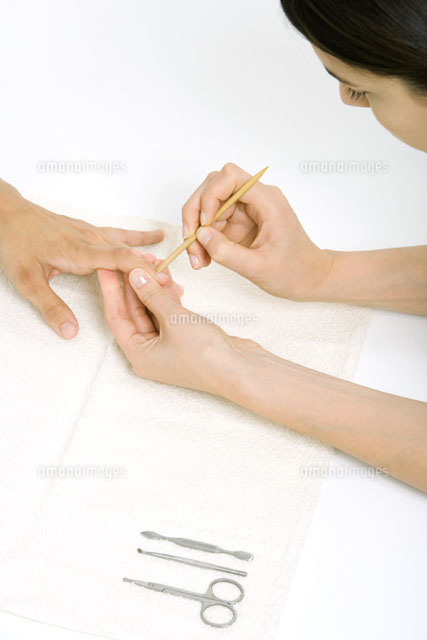 Woman using a cuticle pusher to give a manicure
(c)Alix Minde/PhotoAlto
