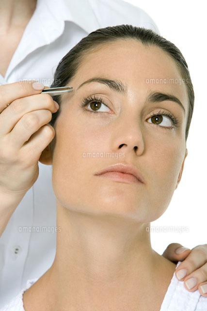 Woman having her eyebrows tweezed, looking up
(c)Alix Minde/PhotoAlto