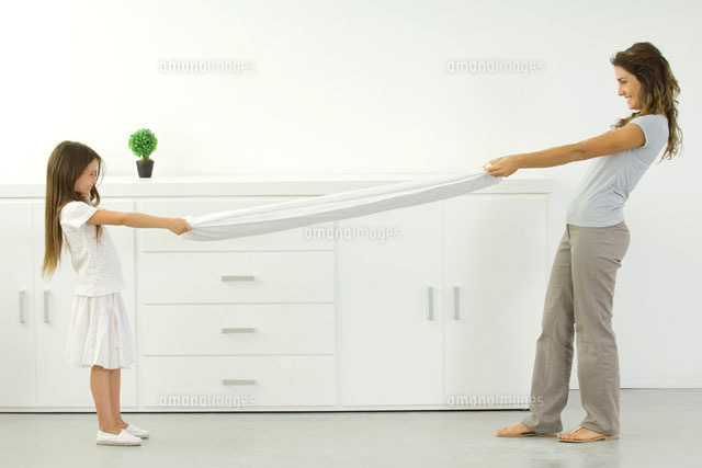 Mother and daughter pulling on opposite ends of sheet
(c)Odilon Dimier/PhotoAlto