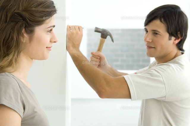 Couple smiling at each other, man hammering nail into wall
(c)Odilon Dimier/PhotoAlto