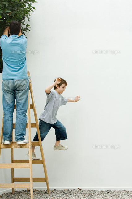 Father and son standing on ladder, boy leaping off
(c)Odilon Dimier/PhotoAlto