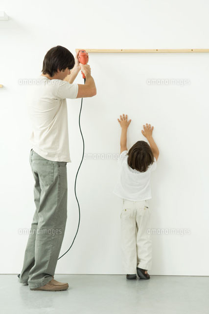 Man drilling into wall, his son reaching up
(c)Odilon Dimier/PhotoAlto