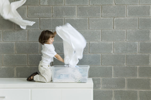 Little boy playing with laundry, smiling, side view
(c)Odilon Dimier/PhotoAlto