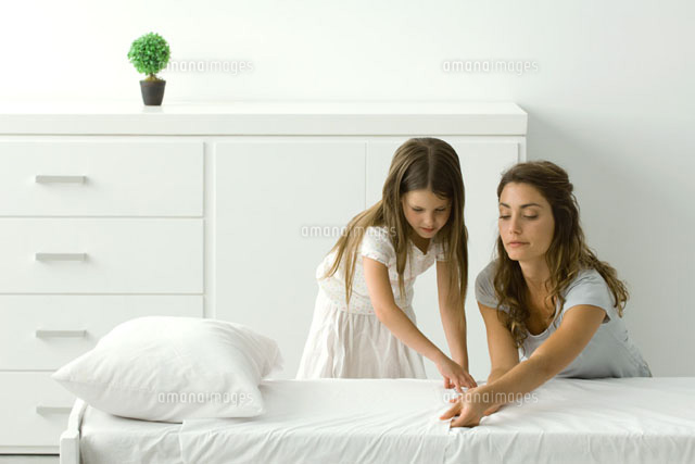 Mother and daughter making bed together
(c)Odilon Dimier/PhotoAlto