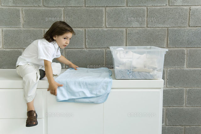 Little boy folding laundry, sitting on counter
(c)Odilon Dimier/PhotoAlto