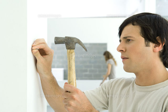 Man hammering nail into wall, woman
(c)Odilon Dimier/PhotoAlto