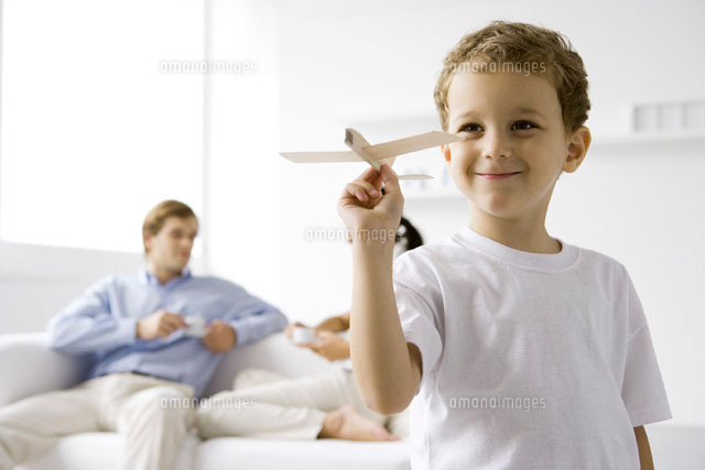 Boy playing with toy airplane, parents sitting on couch
(c)Sigrid Olsson/PhotoAlto