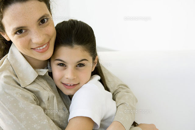 Young woman and girl hugging each other, smiling at camera
(c)Sigrid Olsson/PhotoAlto
