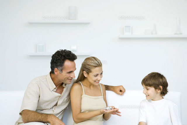 Family sitting together on sofa,mother holding tiny present
(c)Sigrid Olsson/PhotoAlto