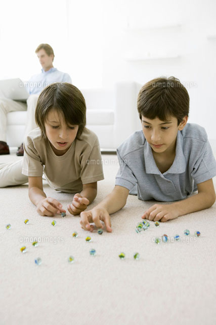 Boys lying on the floor playing with marbles
(c)Sigrid Olsson/PhotoAlto