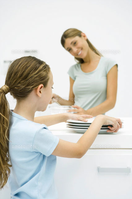 Girl picking up plates, mother smiling at her
(c)Sigrid Olsson/PhotoAlto