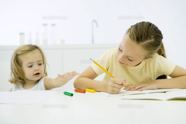 Girl doing homework, younger sister reaching for markers
(c)Sigrid Olsson/PhotoAlto