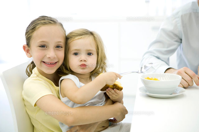 Young girl sitting on her older sister’s lap
(c)Sigrid Olsson/PhotoAlto