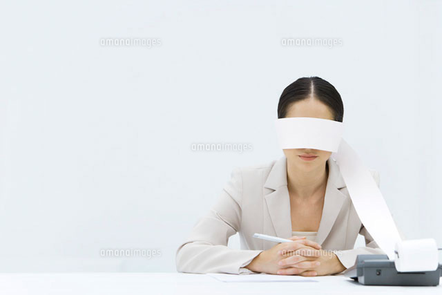 Woman sitting at table with adding machine tape wrapped
(c)Alix Minde/PhotoAlto