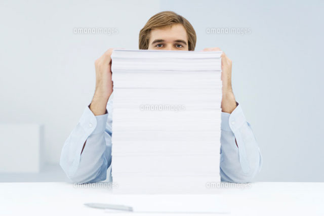 Man peering over tall stack of paper
(c)Alix Minde/PhotoAlto