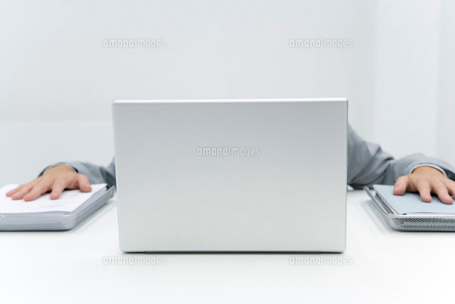 Man hiding laptop putting palms on stacks of paper
(c)Alix Minde/PhotoAlto
