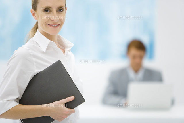 Woman holding folder and smiling at camera
(c)Alix Minde/PhotoAlto