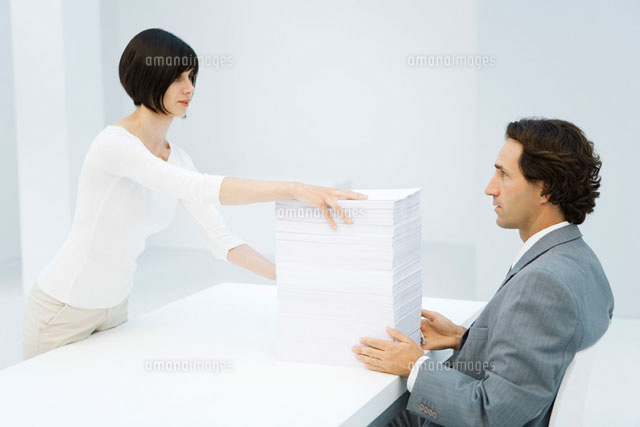 Professional woman and man exchanging tall stack of paper
(c)Alix Minde/PhotoAlto