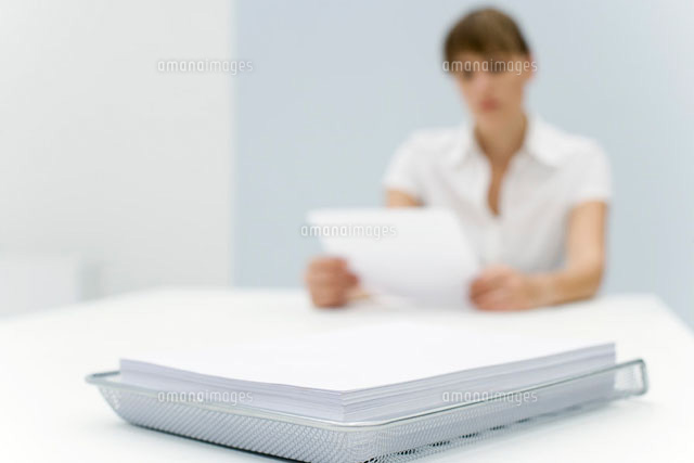 Stack of paper in metal tray, woman reading document
(c)Alix Minde/PhotoAlto
