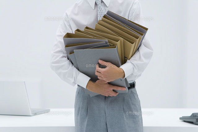 Man holding many binders, cropped view
(c)Alix Minde/PhotoAlto