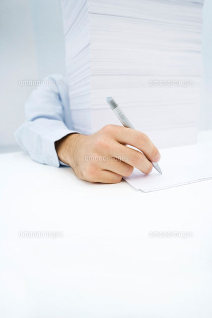 Arm reaching around massive stack of paper to write
(c)Alix Minde/PhotoAlto