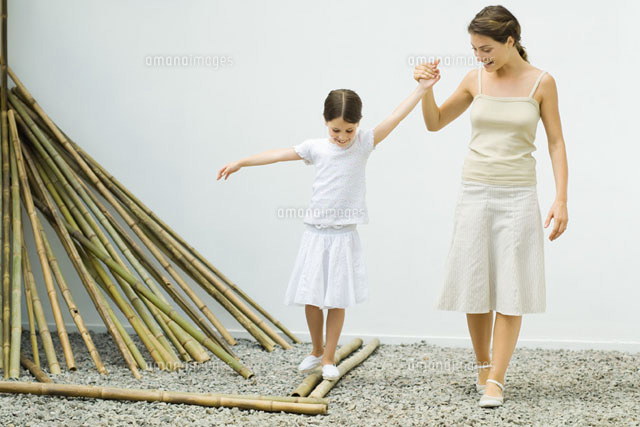Girl balancing on bamboo, mother helping her
(c)Eric Audras/PhotoAlto