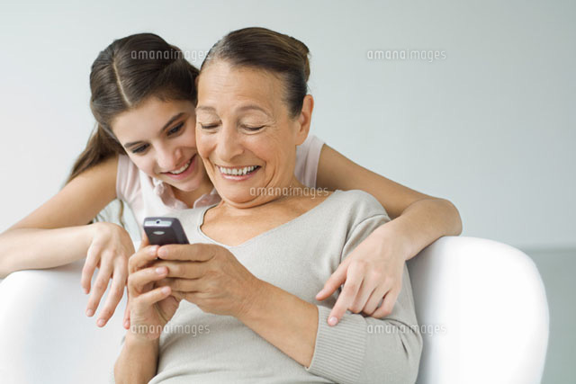 Grandmother holding cell phone, granddaughter looking over
(c)Eric Audras/PhotoAlto