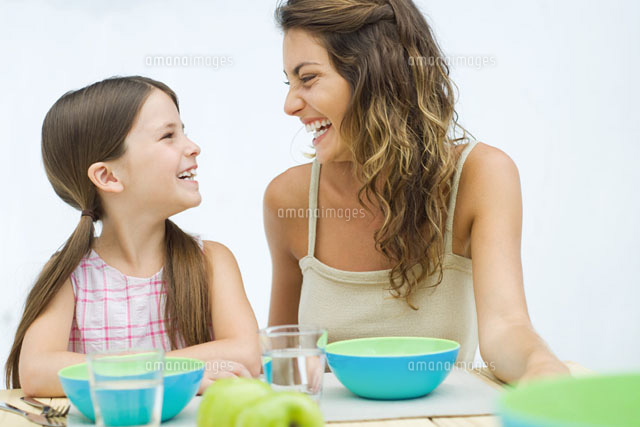 Mother and daughter sitting at table,laughing at each other
(c)Eric Audras/PhotoAlto