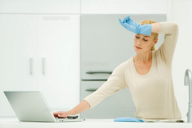 Woman standing at kitchen sink,reaching for laptop computer
(c)Alix Minde/PhotoAlto