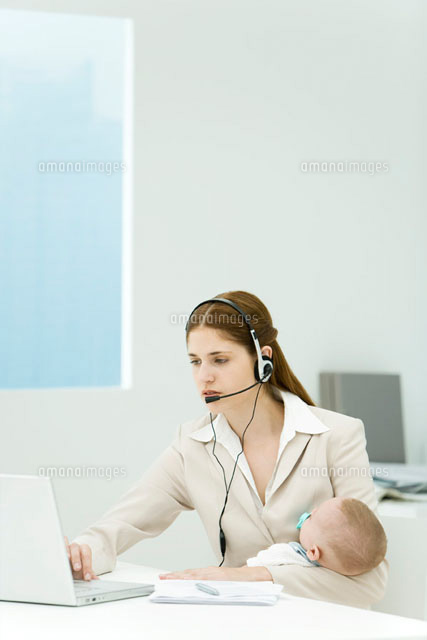 Professional woman in office, holding baby,
(c)Alix Minde/PhotoAlto
