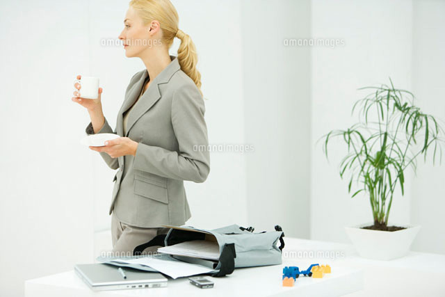 Professional woman holding coffee cup, looking away
(c)Alix Minde/PhotoAlto