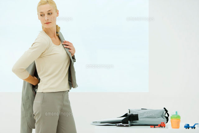 Professional woman dressing, looking over shoulder
(c)Alix Minde/PhotoAlto