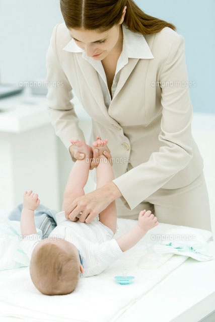 Professional woman changing baby’s diaper on desk
(c)Alix Minde/PhotoAlto
