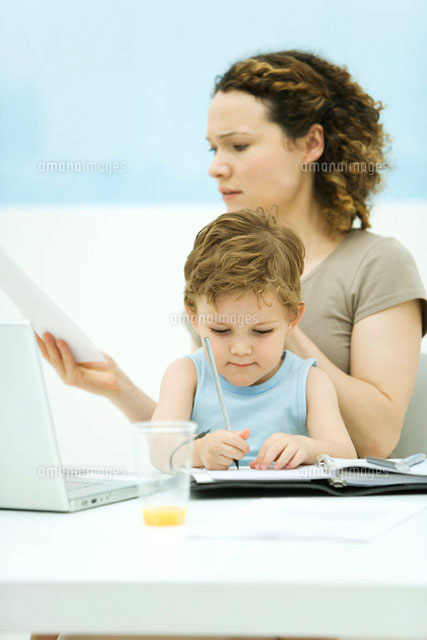 Mother holding son on lap, sitting in front of laptop
(c)Alix Minde/PhotoAlto