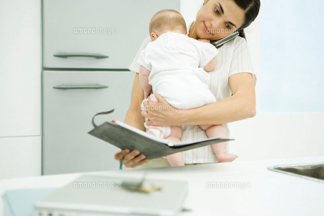 Woman holding baby, using cell phone and looking at agenda
(c)Alix Minde/PhotoAlto