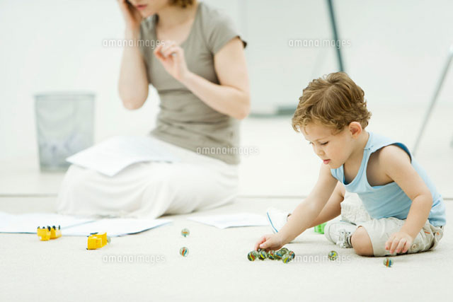 Little boy sitting on the ground, playing marbles
(c)Alix Minde/PhotoAlto