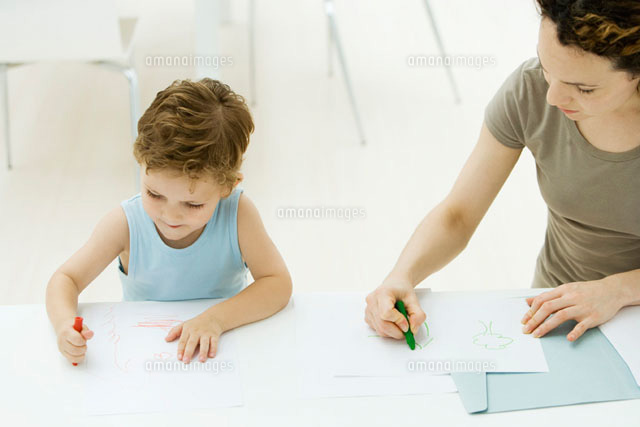 Mother and son sitting side by side, coloring with crayons
(c)Alix Minde/PhotoAlto