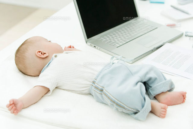 Infant sleeping on desk beside laptop computer
(c)Alix Minde/PhotoAlto