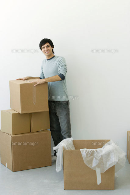 Man standing by stack of cardboard boxes, smiling at camera
(c)Alix Minde/PhotoAlto