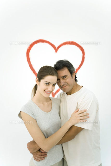 Couple hugging each other in front of heart painted on wall
(c)Alix Minde/PhotoAlto