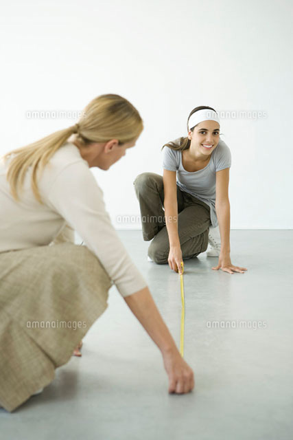 Mother and daughter using measuring tape on the floor
(c)Alix Minde/PhotoAlto