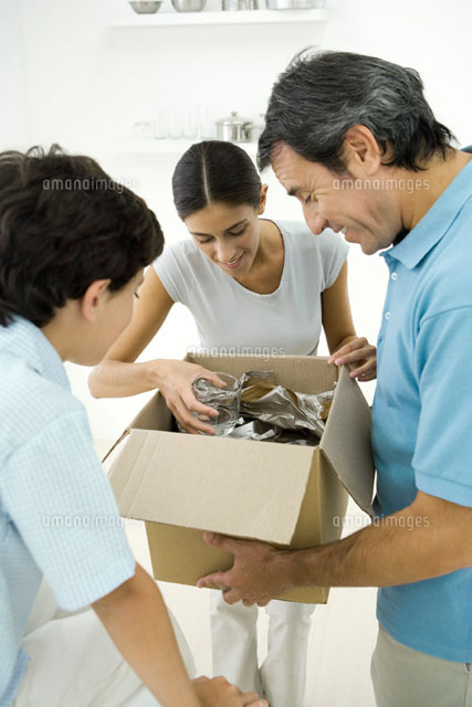 Family unpacking box together
(c)Alix Minde/PhotoAlto